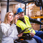 Young warehouse workers working together.